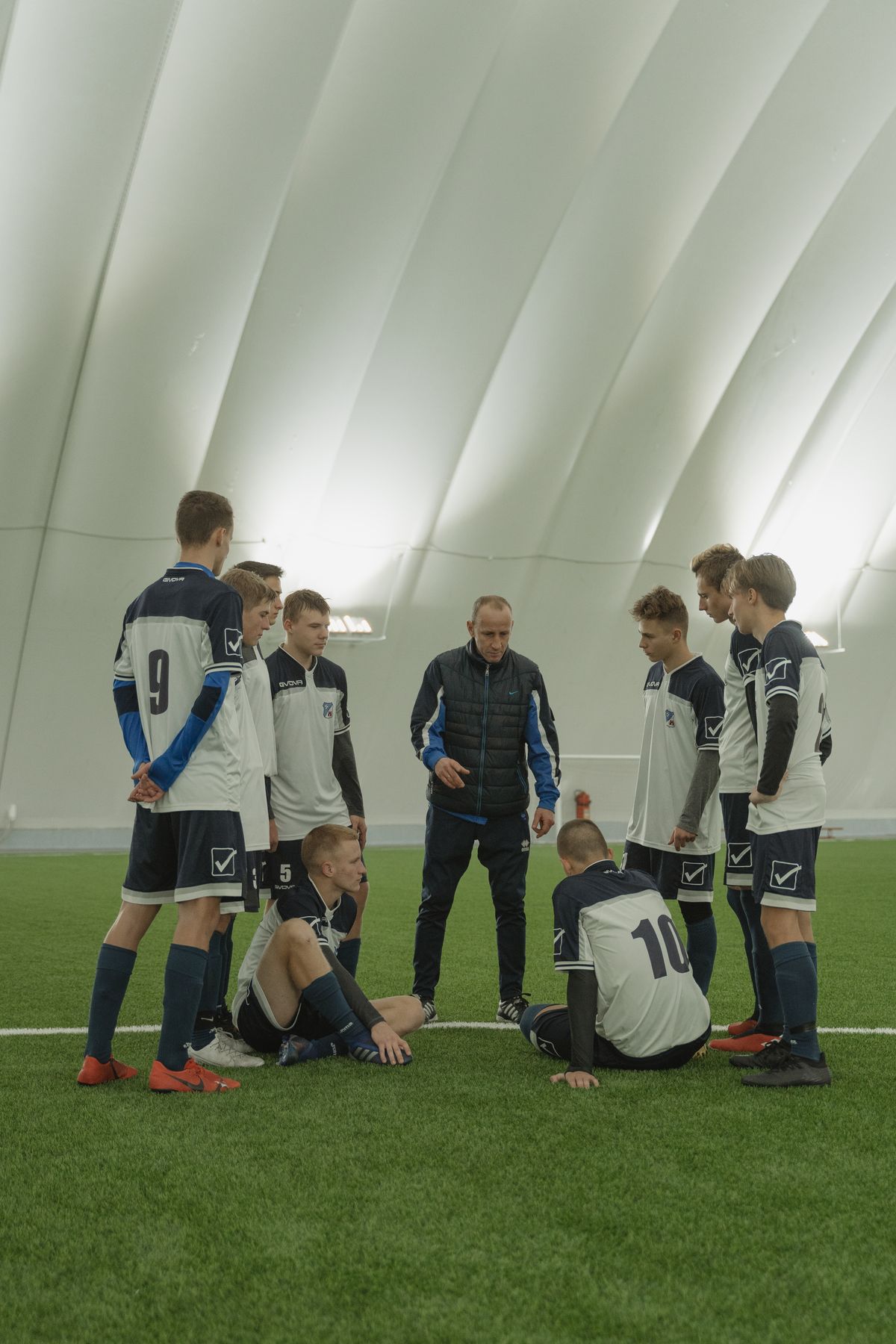 Coach addressing a youth team indoors