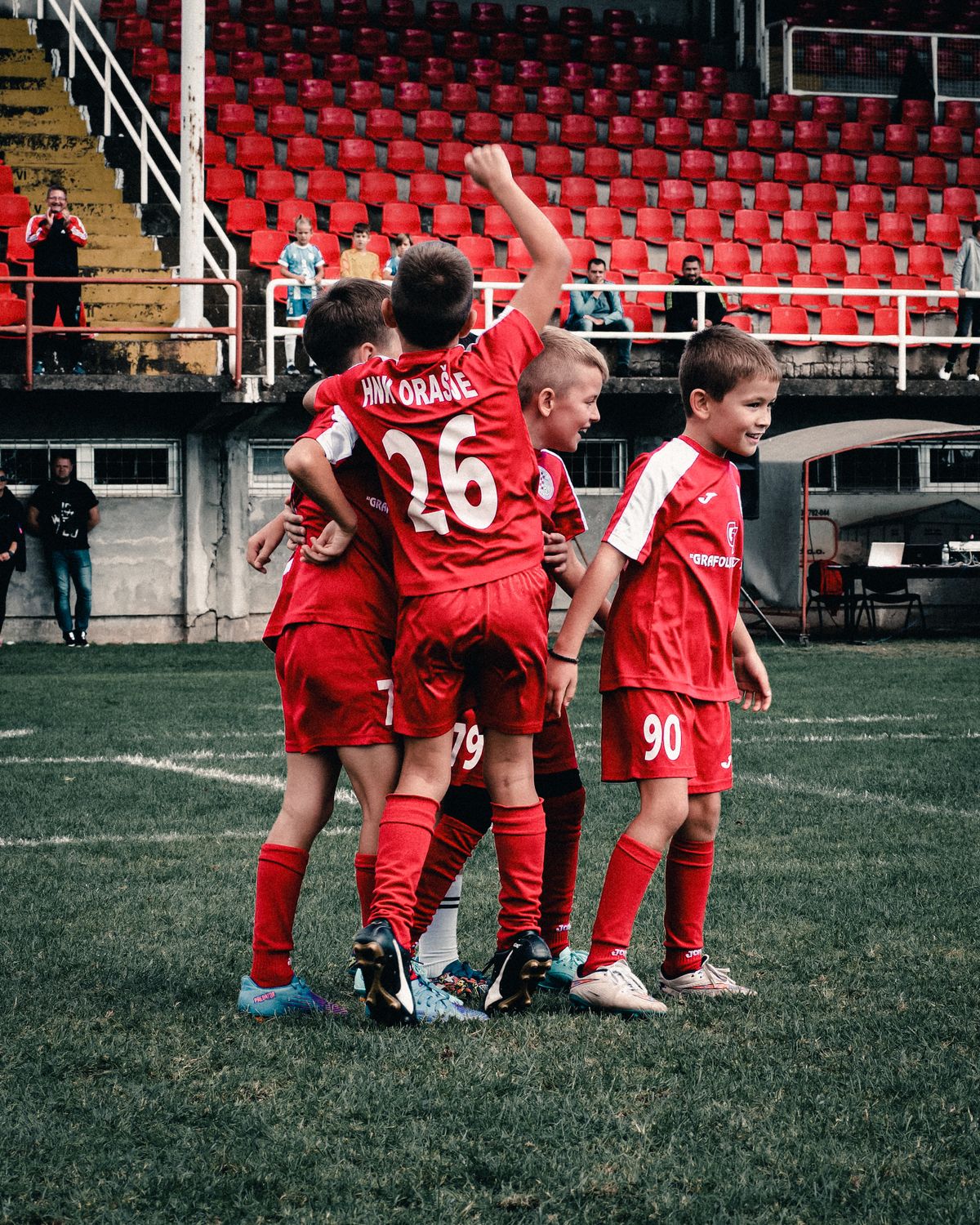 Young players in red celebrating on the field