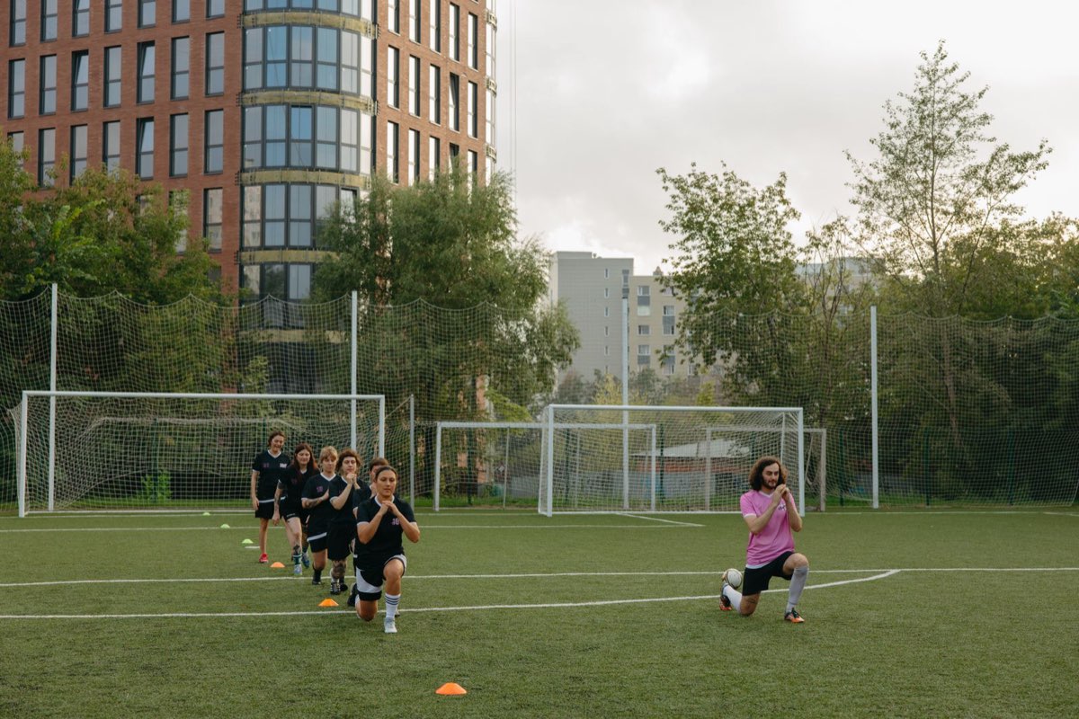 Coach running a warm-up drill with young players at a clinic