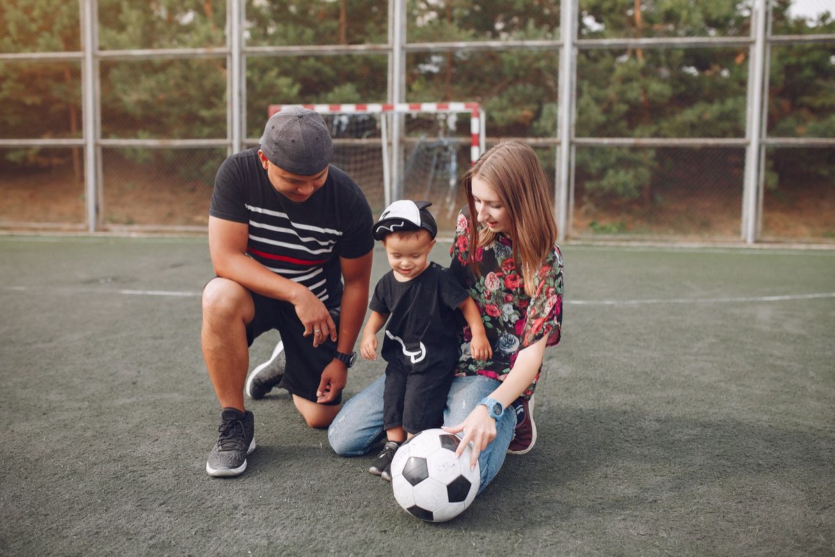 Parents at the field with their child and a ball