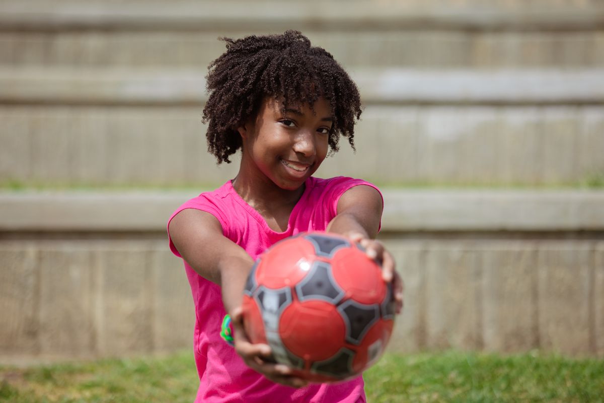 Smiling young athlete holding a ball